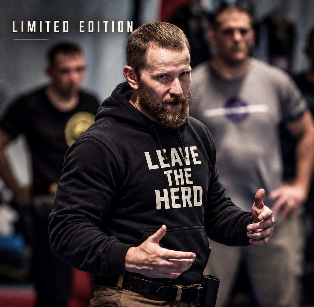 image of a man wearing the black hoodie for sale that says in big, bold, off while letters "Leave The Herd"